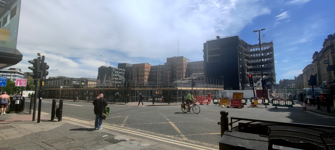 A building demolition in progress around a busy intersection.