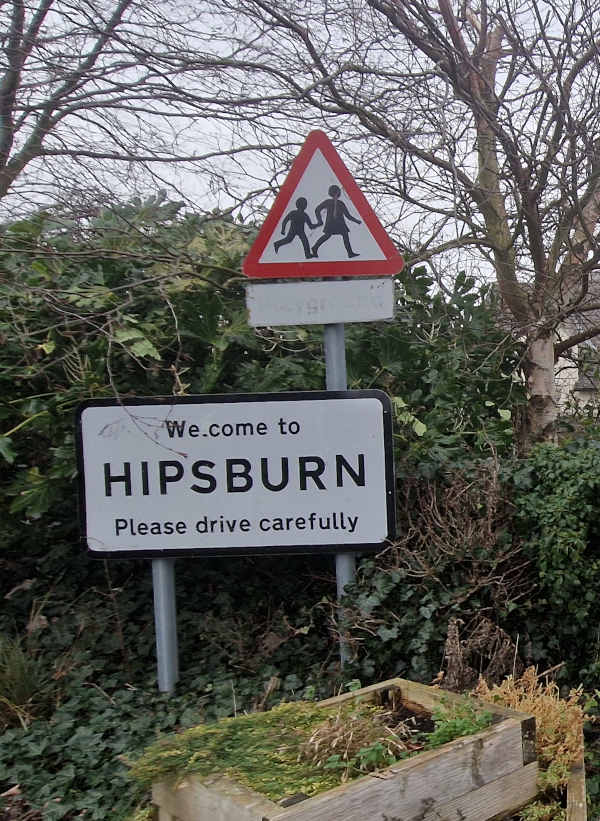 A sign reading “Welcome to Hipsburn — Please drive carefully”